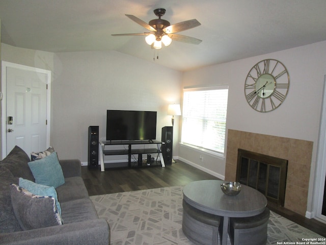 living room featuring ceiling fan, lofted ceiling, dark wood-type flooring, and a fireplace