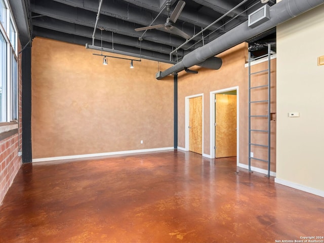 unfurnished room featuring ceiling fan and concrete flooring