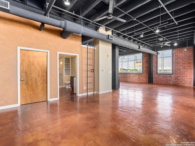 interior space featuring brick wall and ceiling fan