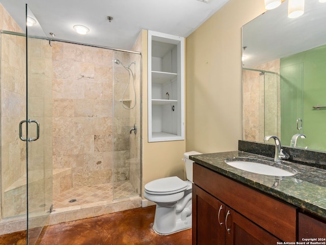 bathroom featuring oversized vanity, toilet, and a shower with door