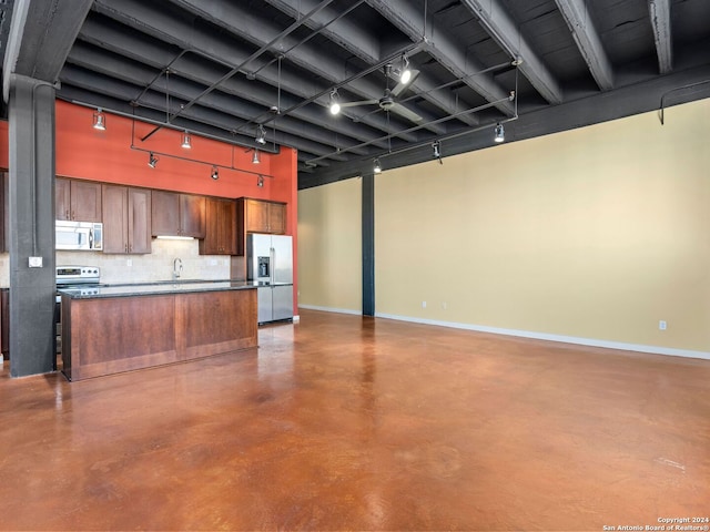 kitchen featuring backsplash, appliances with stainless steel finishes, sink, and concrete flooring