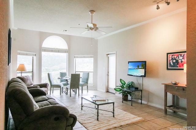 living room with ceiling fan, rail lighting, light tile floors, ornamental molding, and a textured ceiling