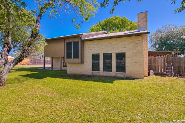 rear view of house featuring a yard