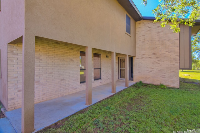 rear view of property featuring a lawn and a patio