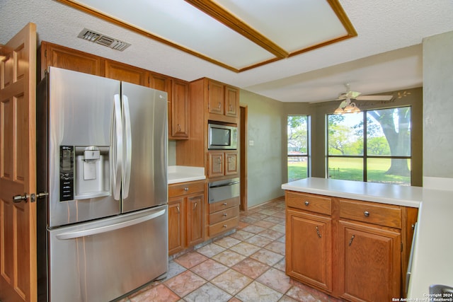 kitchen with appliances with stainless steel finishes, a textured ceiling, ceiling fan, and light tile floors