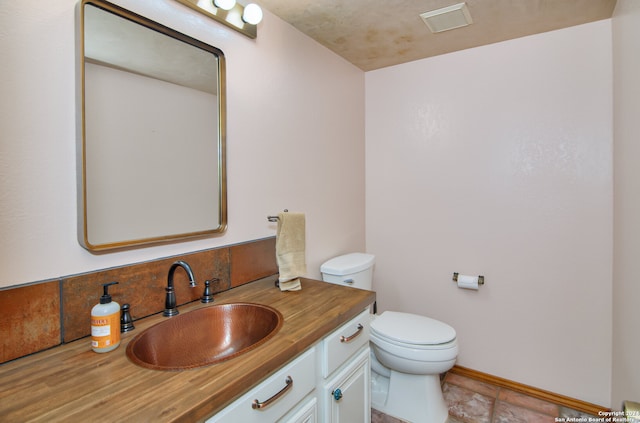 bathroom featuring tile flooring, large vanity, and toilet