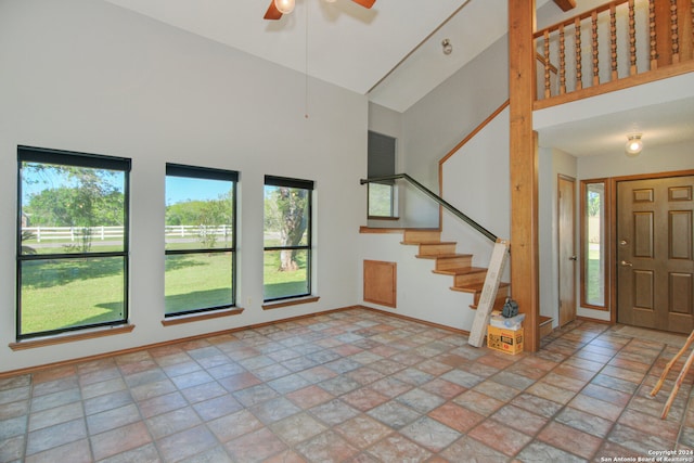 foyer entrance featuring high vaulted ceiling, a healthy amount of sunlight, and tile floors