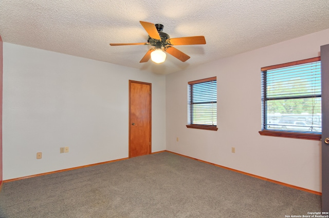 unfurnished room featuring a textured ceiling, ceiling fan, and carpet floors