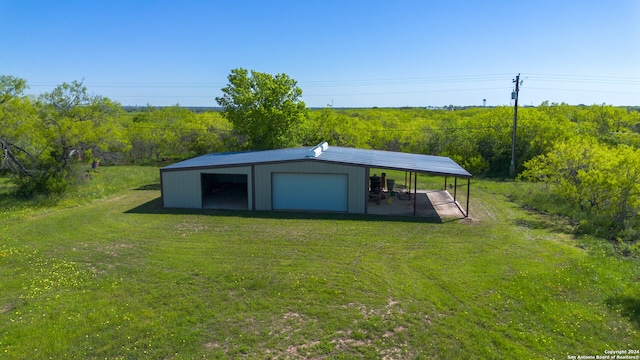 view of outdoor structure with a garage and a lawn