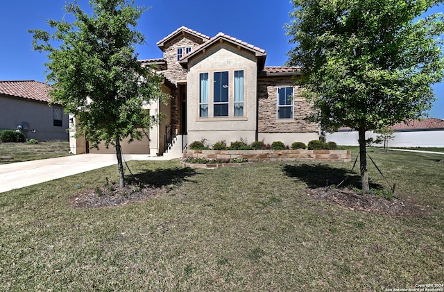 mediterranean / spanish home with a front yard and a garage