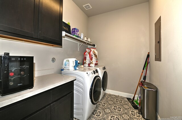 washroom with cabinets, tile floors, and washer and clothes dryer