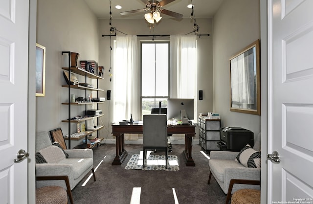 carpeted home office featuring ceiling fan