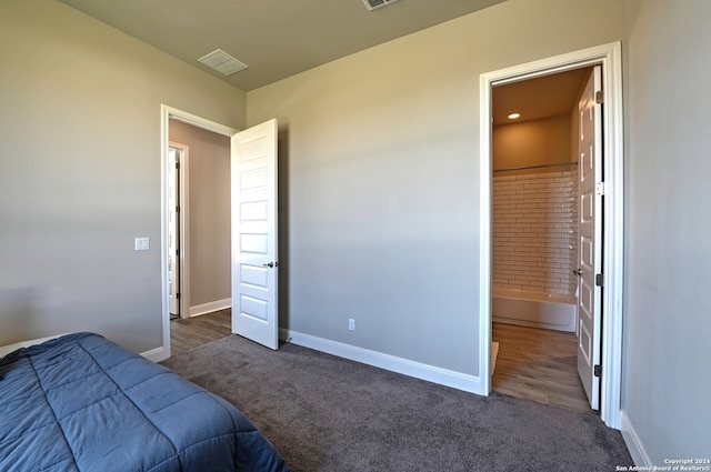 bedroom with dark hardwood / wood-style floors and ensuite bath