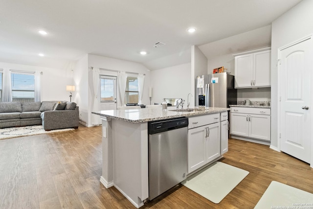 kitchen featuring white cabinets, a center island with sink, light hardwood / wood-style floors, and appliances with stainless steel finishes