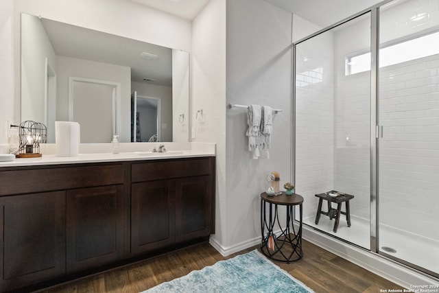 bathroom with an enclosed shower, hardwood / wood-style floors, and vanity