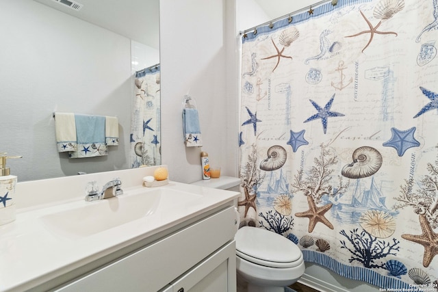 bathroom featuring toilet and vanity with extensive cabinet space