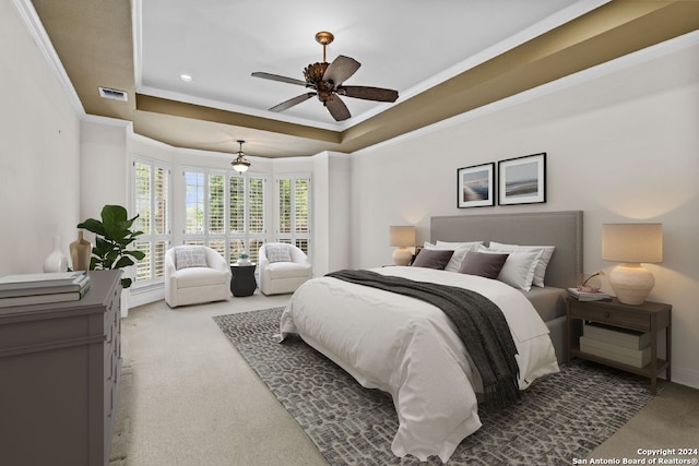 carpeted bedroom with ceiling fan, crown molding, and a tray ceiling