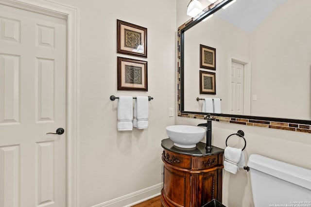 bathroom featuring hardwood / wood-style flooring, toilet, and vanity