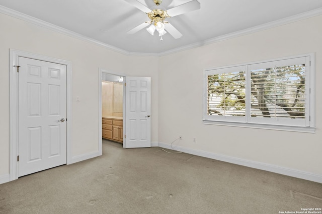 unfurnished bedroom featuring ceiling fan, crown molding, and light colored carpet