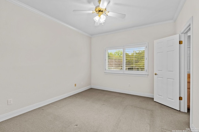 empty room featuring light carpet, crown molding, and ceiling fan