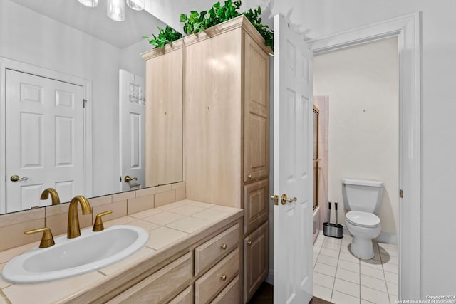 bathroom featuring tile flooring, large vanity, and toilet