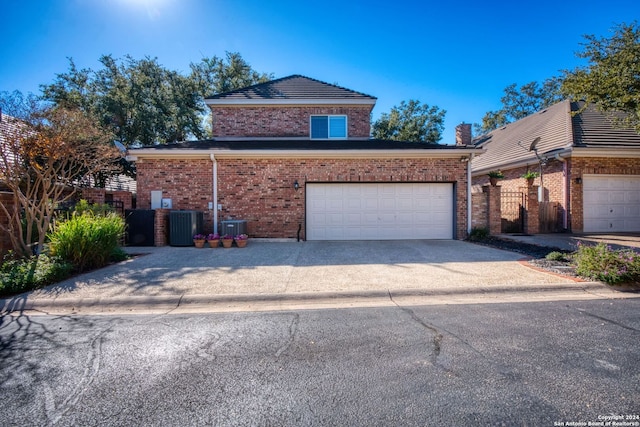 view of property featuring central AC unit and a garage