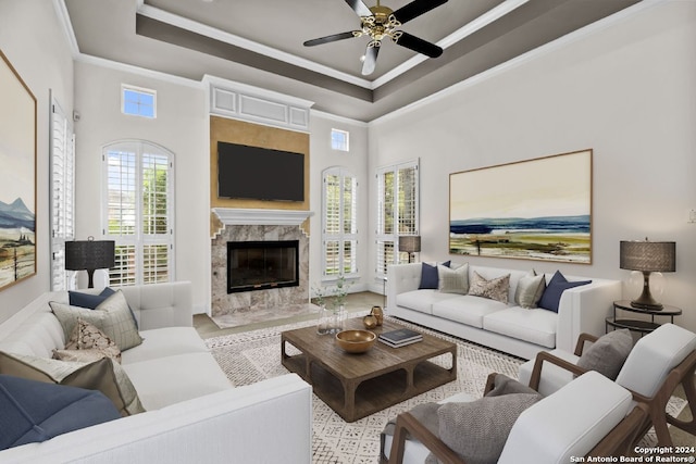 living room with a premium fireplace, crown molding, ceiling fan, a high ceiling, and a raised ceiling