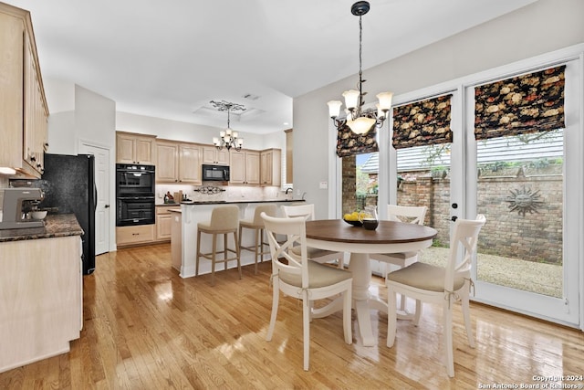 dining area featuring light wood-type flooring and an inviting chandelier