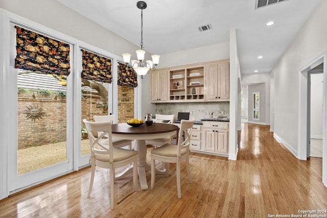 dining space with plenty of natural light, a chandelier, and light hardwood / wood-style flooring