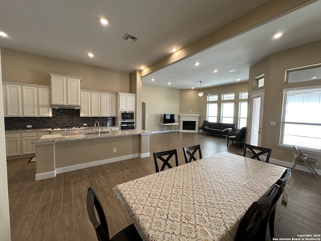 dining space featuring beamed ceiling, sink, and dark wood-type flooring