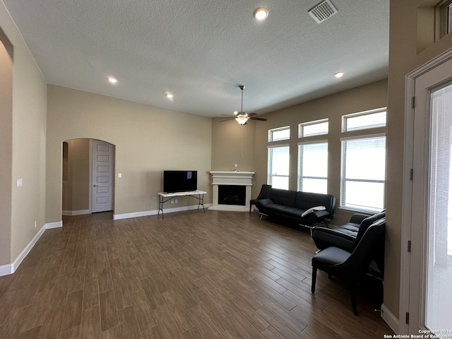 living room featuring a textured ceiling, dark hardwood / wood-style flooring, and ceiling fan