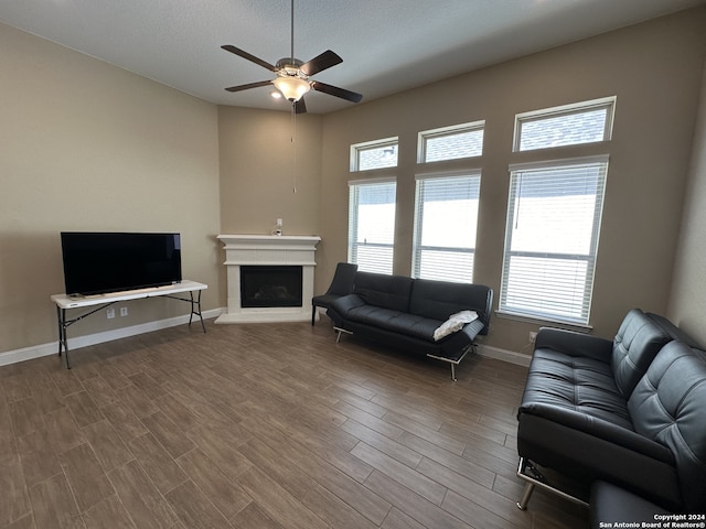 living room with ceiling fan, a textured ceiling, and hardwood / wood-style flooring