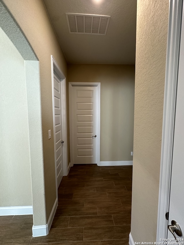 corridor with dark hardwood / wood-style flooring