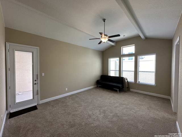 unfurnished room with carpet flooring, vaulted ceiling with beams, and a textured ceiling