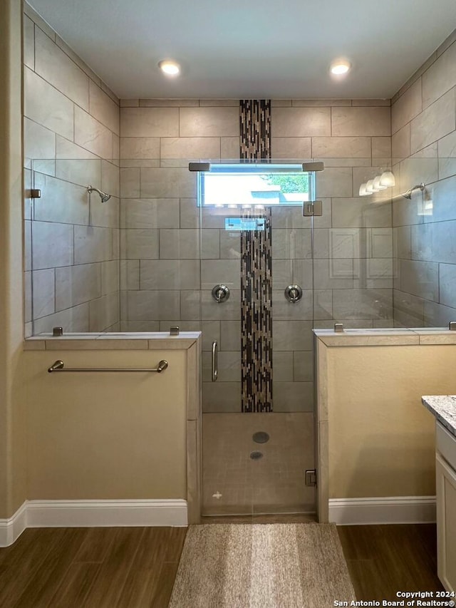 bathroom featuring vanity, wood-type flooring, and a shower with door