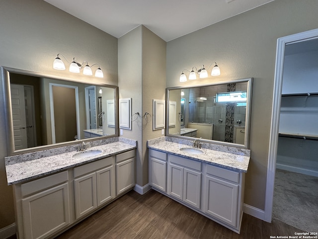 bathroom featuring hardwood / wood-style floors, vanity, and tiled shower