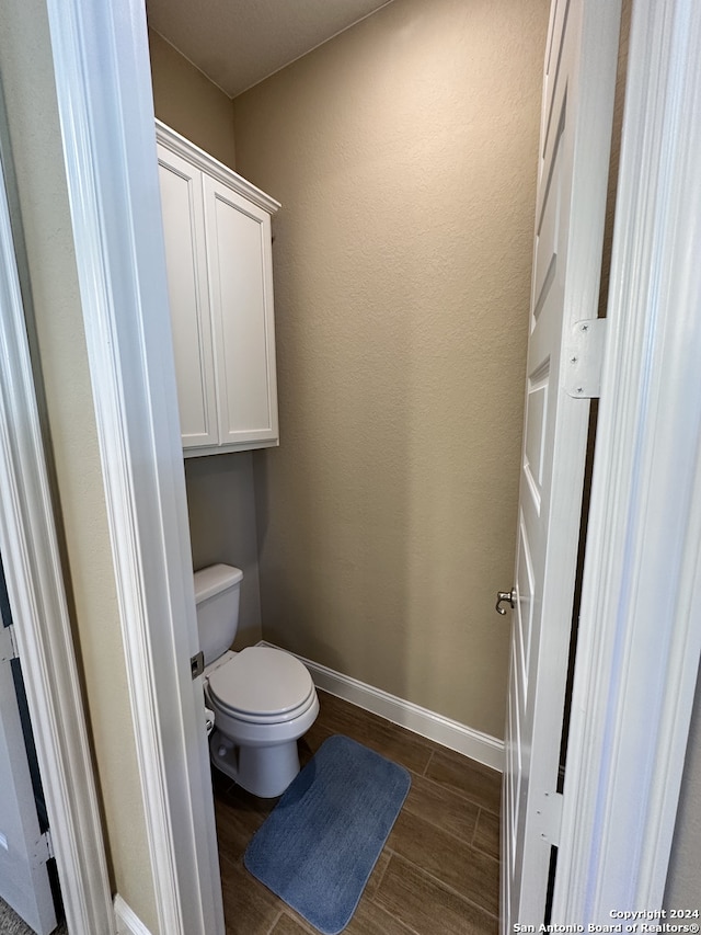 bathroom featuring toilet and wood-type flooring