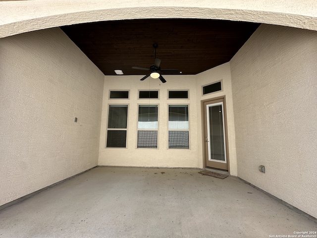 view of exterior entry featuring ceiling fan and a patio