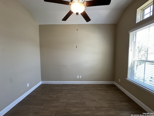 empty room with ceiling fan, dark hardwood / wood-style flooring, and vaulted ceiling