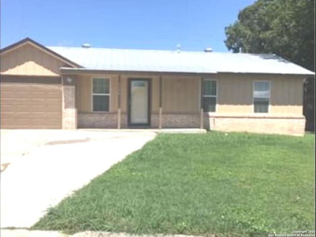 single story home featuring a front yard and a garage