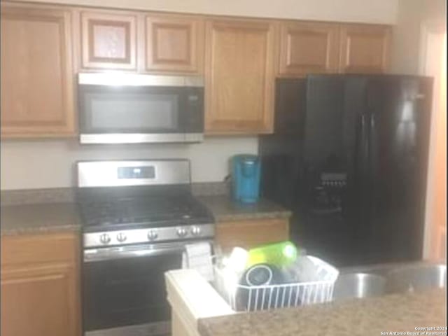 kitchen with stove and light stone counters