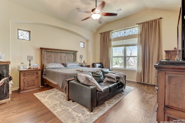 bedroom with ceiling fan, lofted ceiling, and light hardwood / wood-style flooring