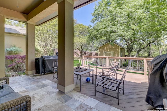 wooden deck featuring a grill and a storage shed