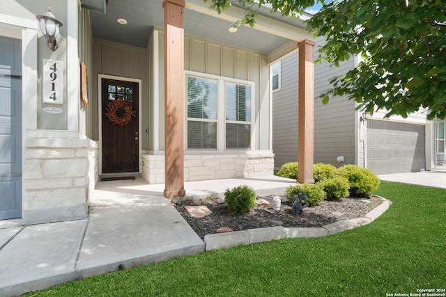 view of exterior entry with a porch and a garage