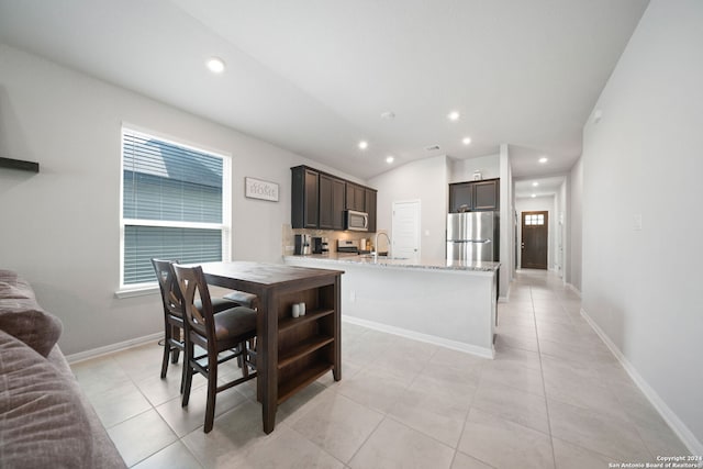 dining room featuring light tile flooring, plenty of natural light, and lofted ceiling