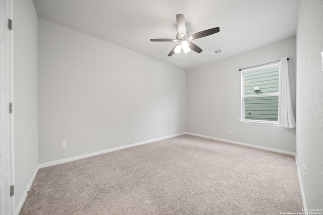 carpeted spare room with ceiling fan