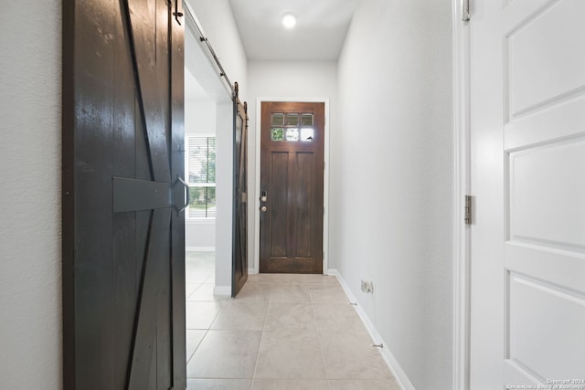 entryway with a barn door and light tile flooring