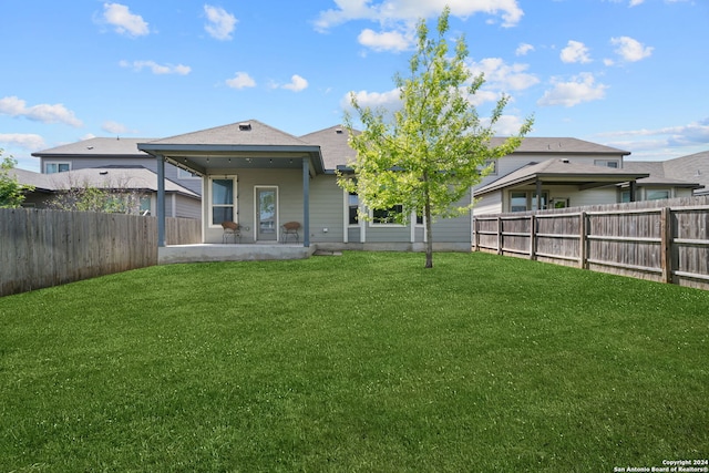 rear view of house featuring a yard