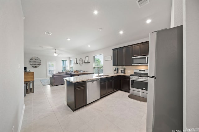 kitchen featuring kitchen peninsula, ceiling fan, light tile flooring, sink, and stainless steel appliances