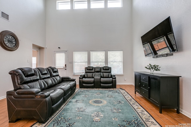 living room with a high ceiling and light wood-type flooring